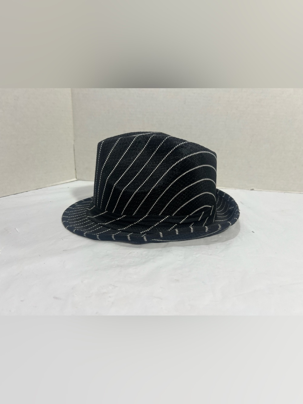 Stylish black fedora with white pinstripes.